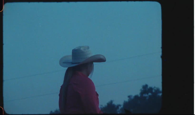 Cowgirl wearing a white hat at evening