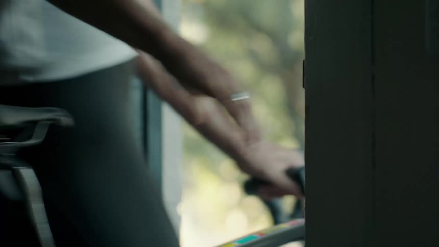 Closeup of a woman opening the door of the house and stepping out with her bicycle