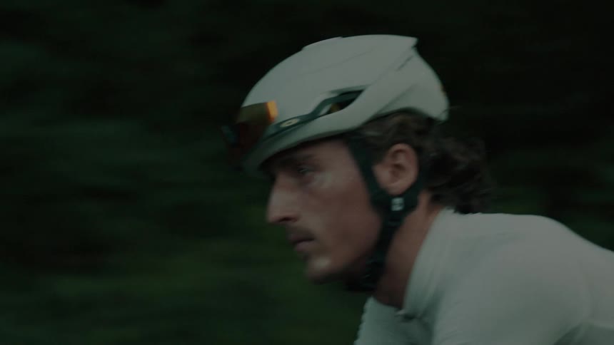 Cyclist pedaling on the road next to vegetation