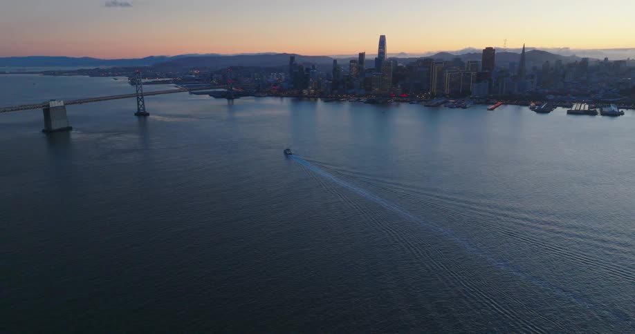 A boat sailing on a large body of water towards a city