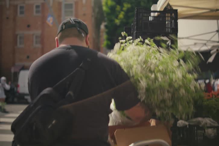 A man takes a seedling from a plant and puts it somewhere else