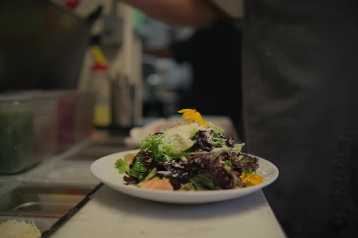 A cook is preparing a salad