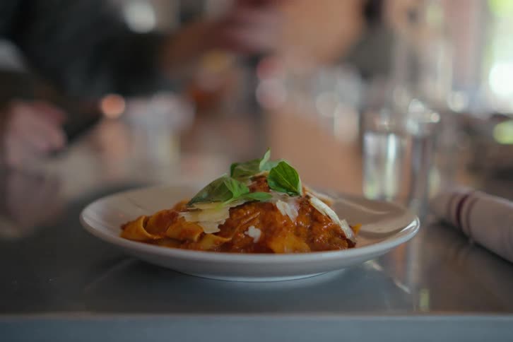 A closeup of a pasta dish served on the counter of a restaurant