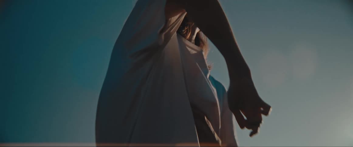 A woman is dancing under the clear sky
