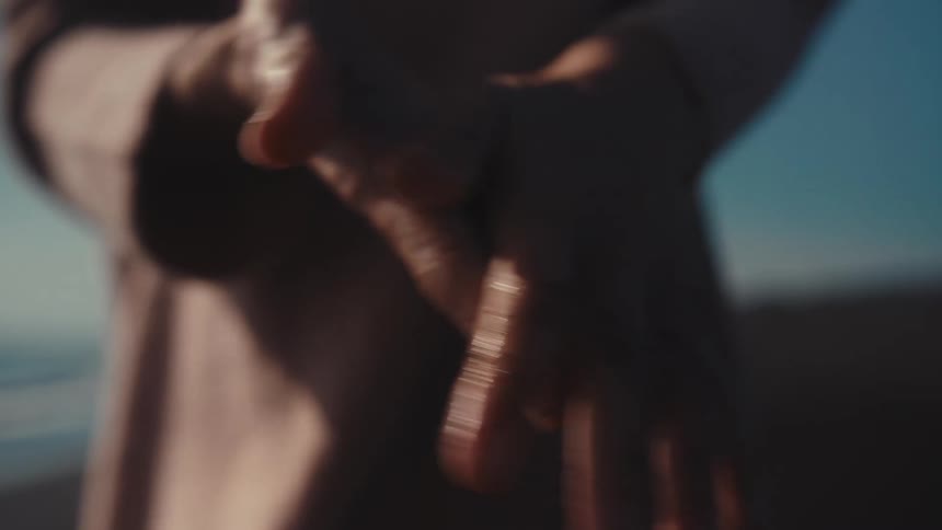 A person rubbing wet hands on the beach sand