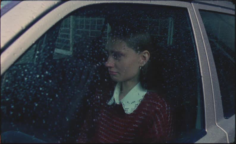 Sad woman crying in her car on a rainy day