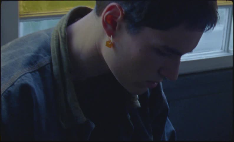 A young sad man sitting on a bench