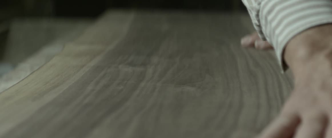 Man rubbing a piece of wood with his hand