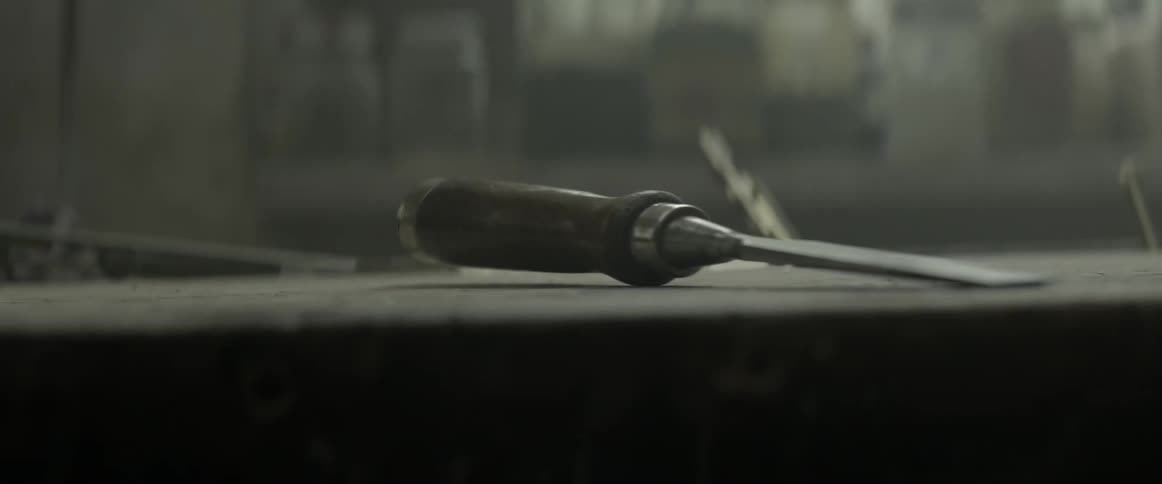 A chisel is sitting on a desk in a workshop