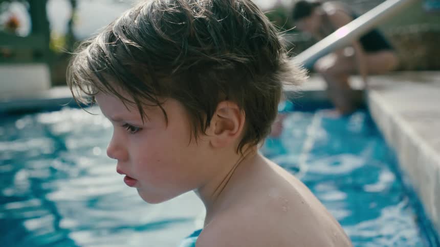 Boy sitting at the edge of a pool