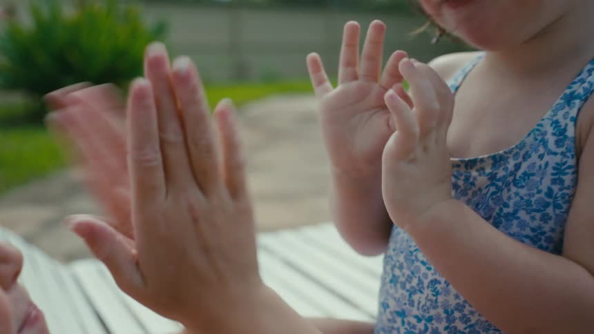 Sisters playing hand clapping games next to the swimming pool