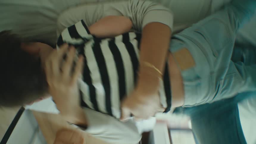 A mother and son play around in the bed