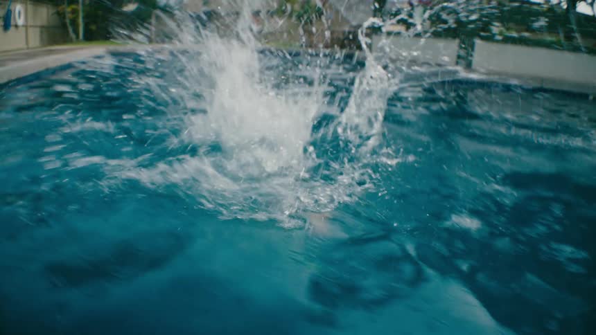 Boy makes a big splash jumping in the pool