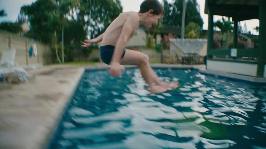 Boy makes a big splash jumping in the pool
