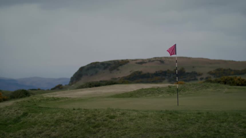 A red flag flying on a golf course