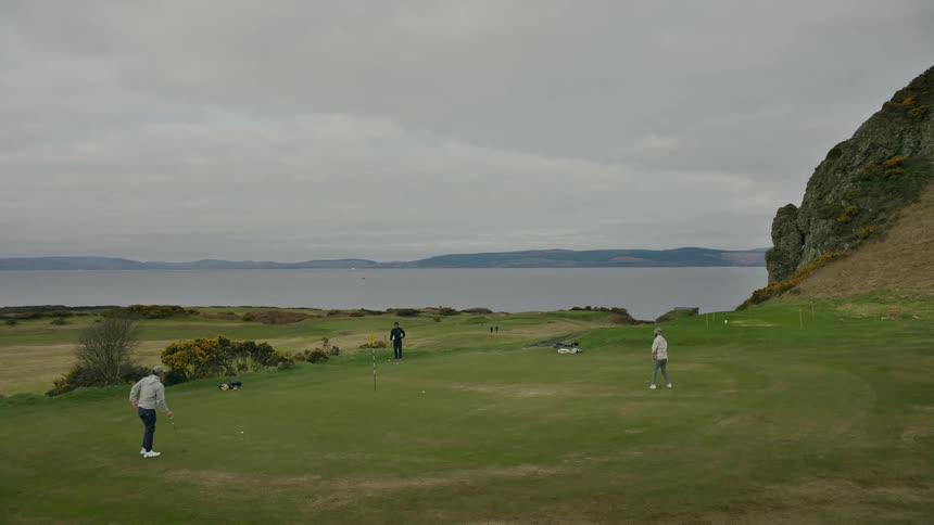 People are playing golf on the course