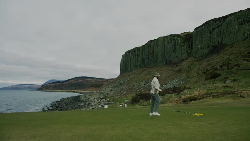 A golfer puts the flag in the hole