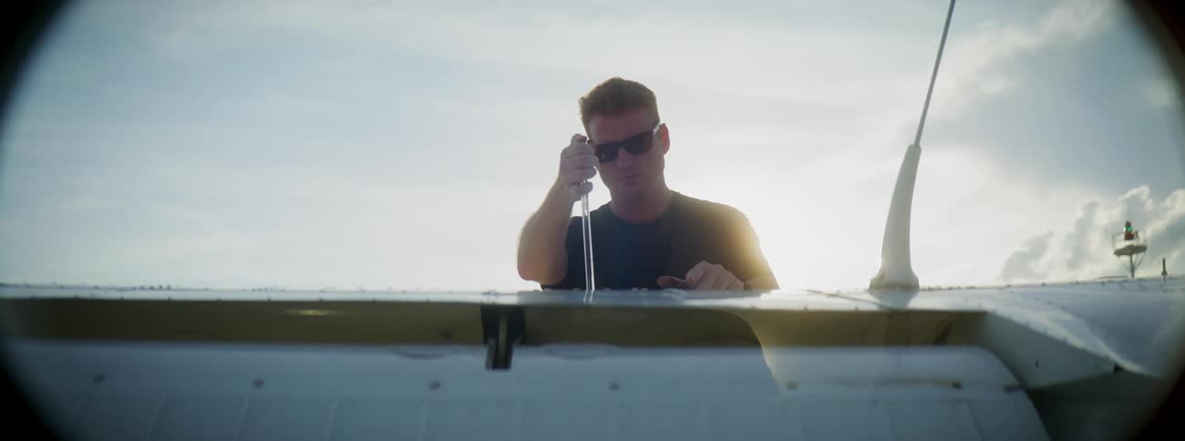 Man wearing sunglasses outdoors on a sailboat on a sunny day