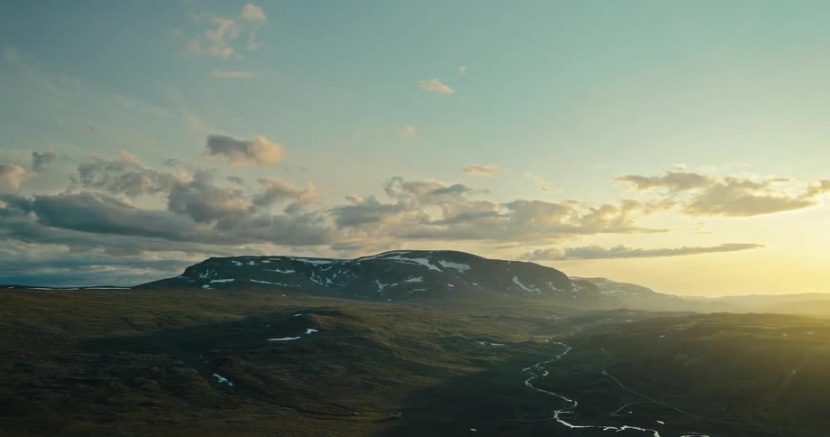 Aerial of a mountain valley with a stream during the early morning