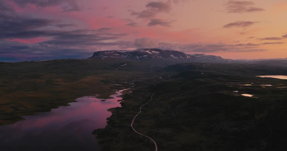 A scenic landscape of rivers and lakes with mountains in the foreground at sunset