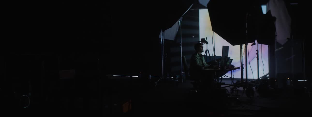 A man is looking at the computer in the studio