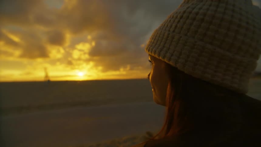 Face of a lady standing by the road side watching passersby at sunset