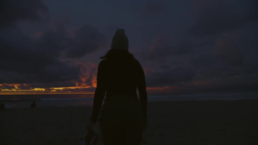 A lady walking towards the beach
