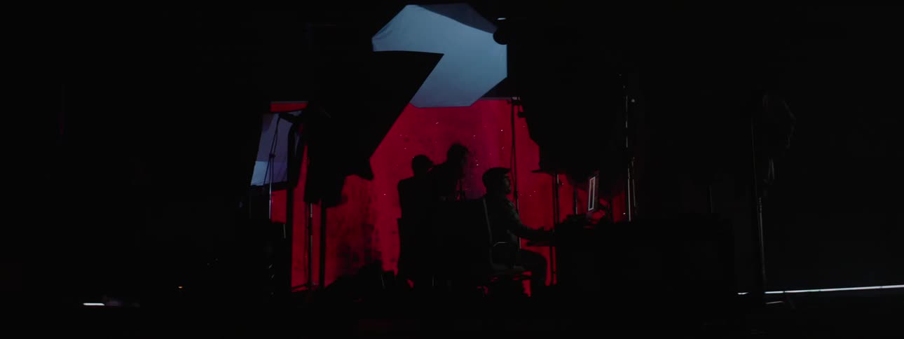 People working on a computer in a photography set with a large projector in the background