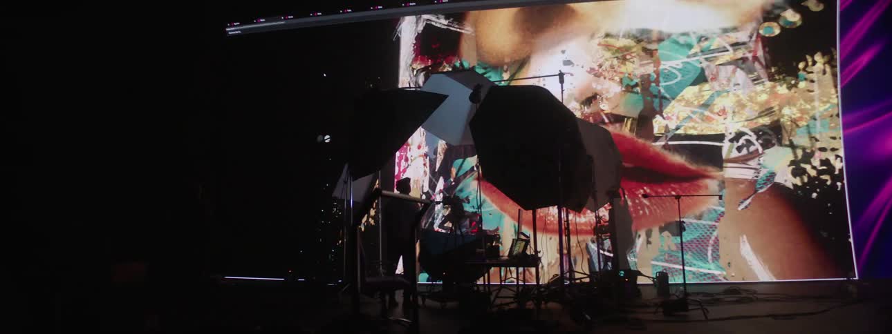 Model and photographer in front of a giant digital screen