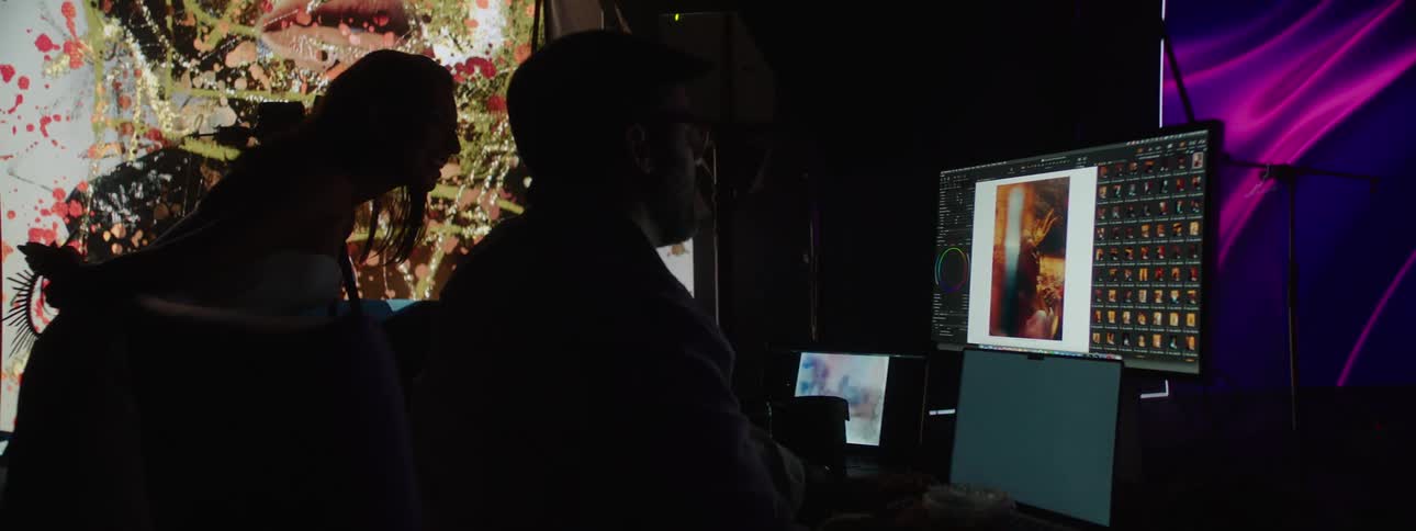 Two photographers editing pictures on a computer in the stage