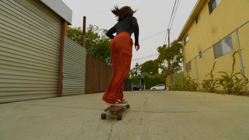 Woman riding a skateboard on an alley in town