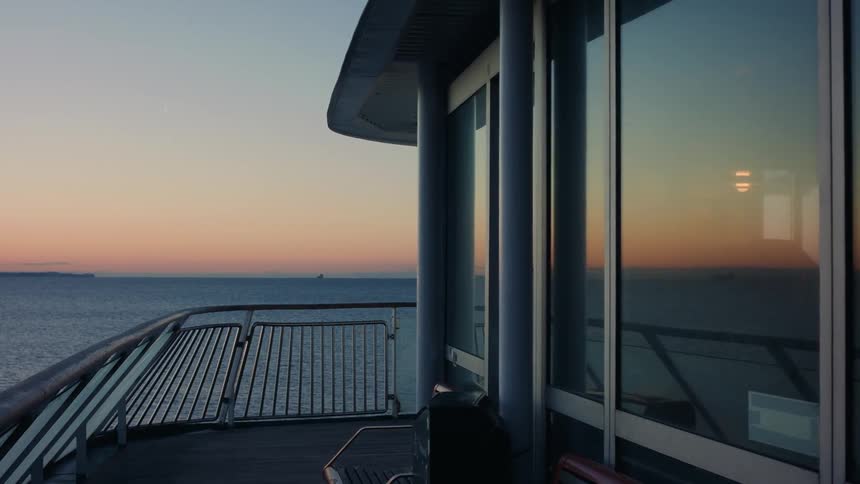 View from inside a moving boat over the sea under a dawn sky