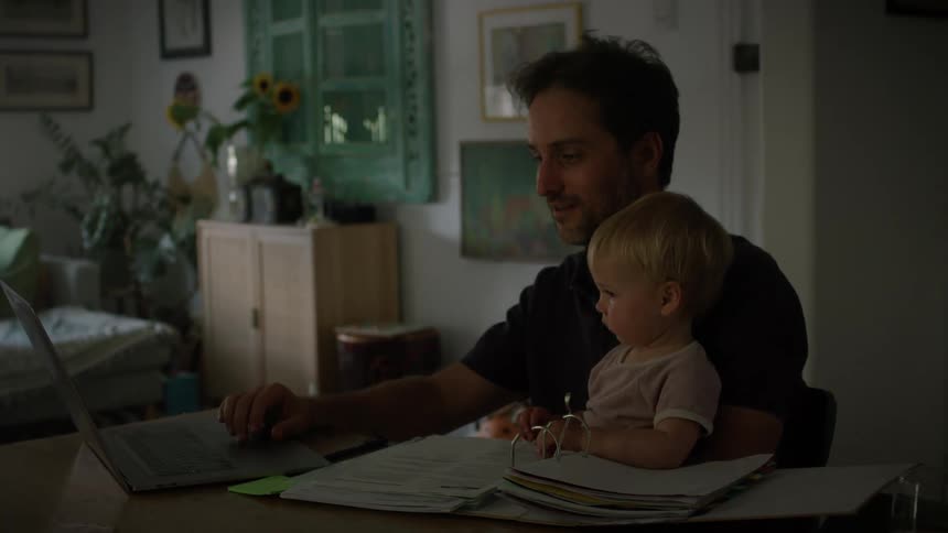 Father and child both wave at screen during workrelated video call from home