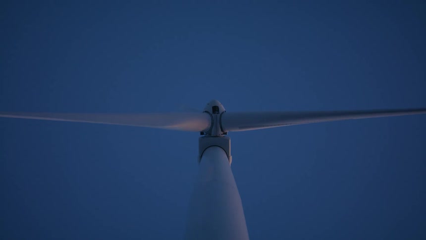 A wind turbine rotates during the day