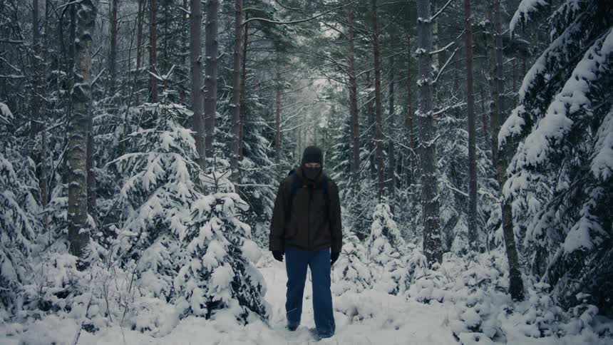 Man walking through a snowcovered forest