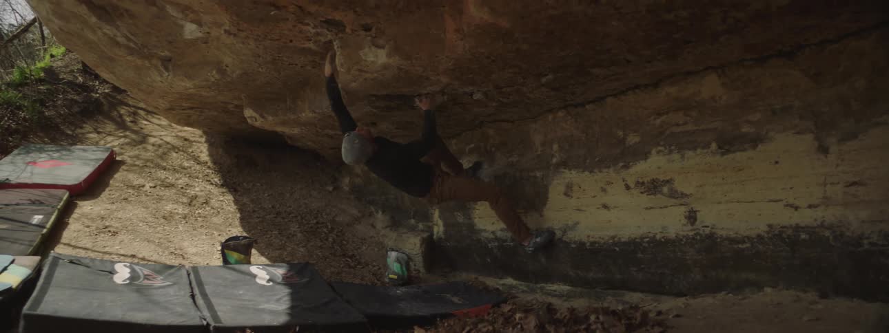 A man climbing a rocky mountain during the day
