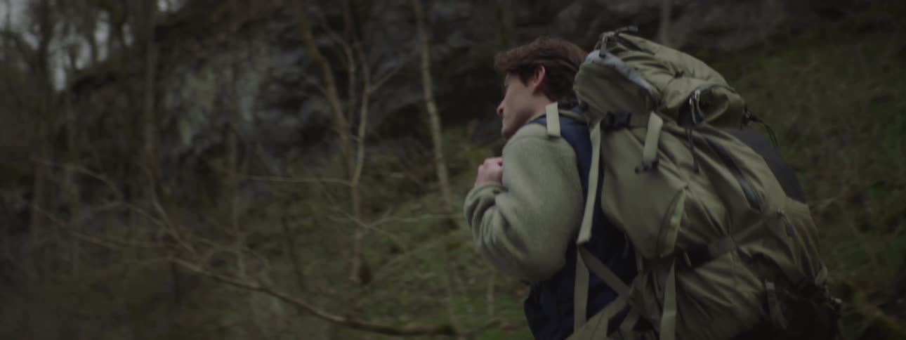 A backpacker hiking across the woods