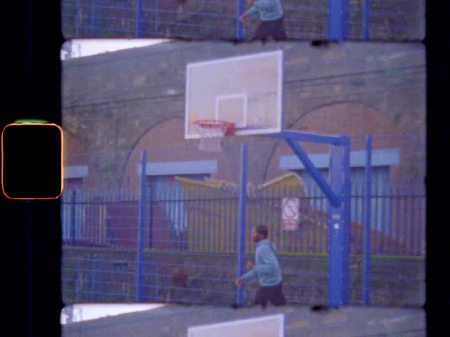 A man playing basketball makes a layup