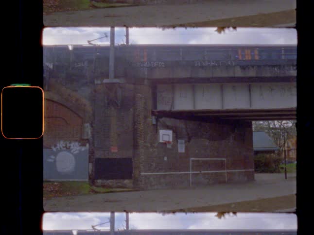 A train moving across a bridge with a basketball hoop