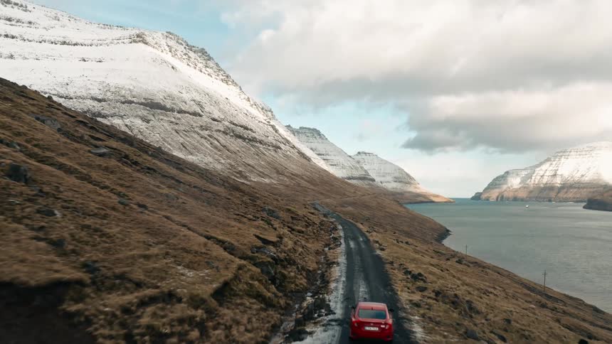 Skyline of a car driving along a dangerous road between mountains and sea