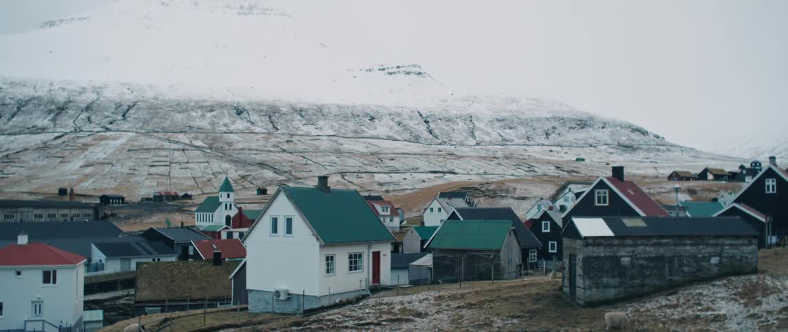 A view of some houses outdoors in a rural area on a snowy day