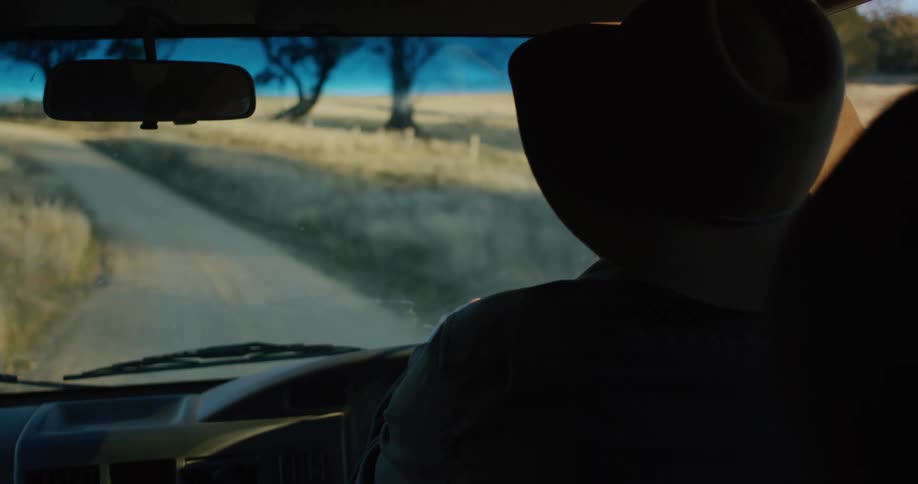 Close up of a person driving a car on a small countryside road