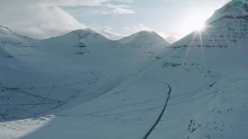 A long road across a snow covered mountain range