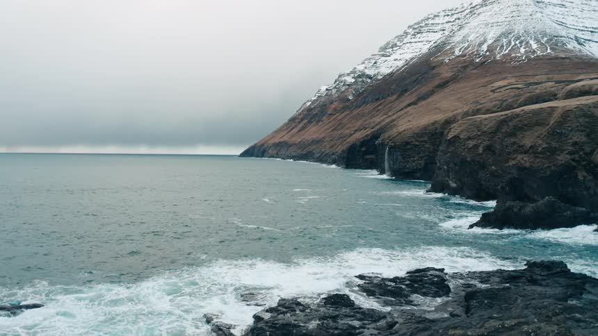 Panorama of snowcovered mountains next to the sea