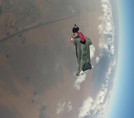 A person is wingsuit flying high above