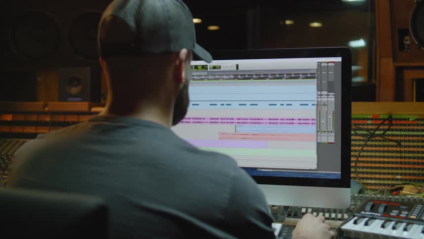 A man in a music studio using a computer program