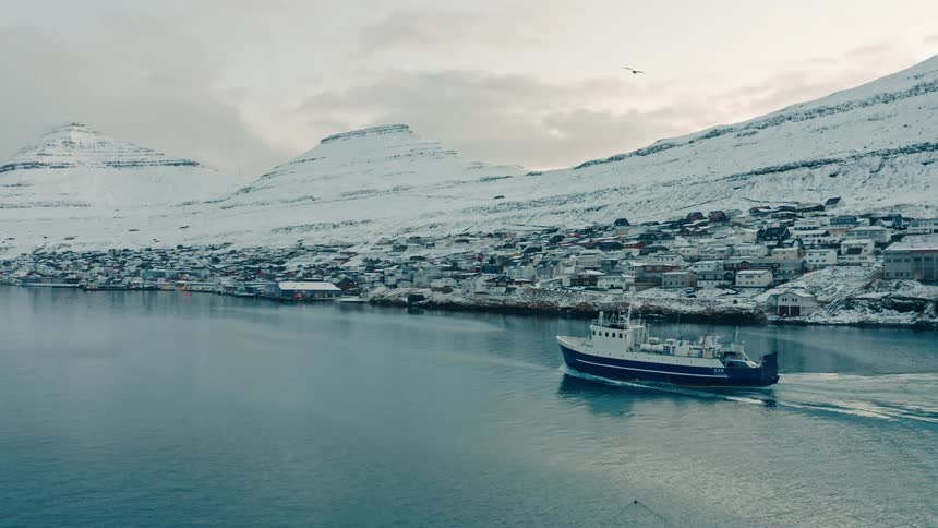 Aerial of a coastal city in the arctic between mountains