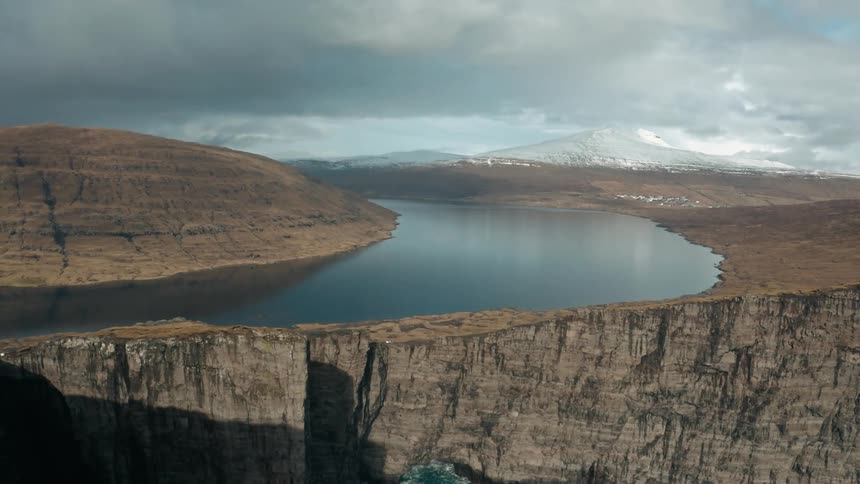 Aerial view of river and dry mountain terrain on cloudy day