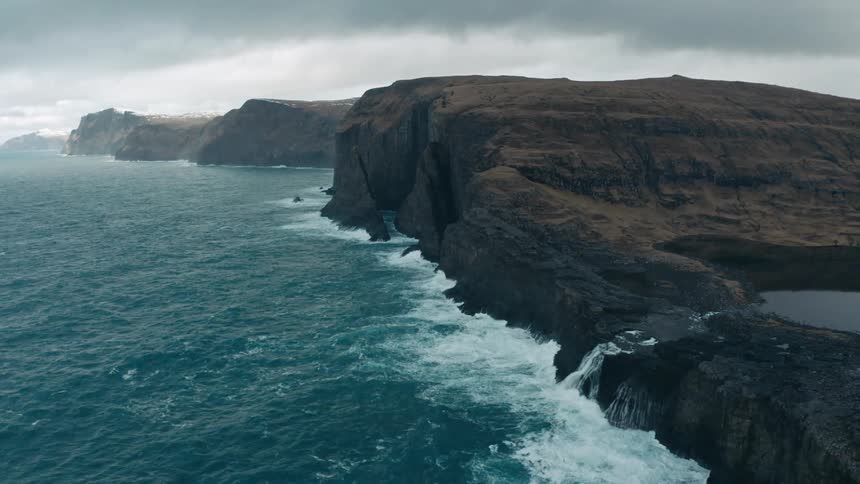The sea hitting a tall cliff face