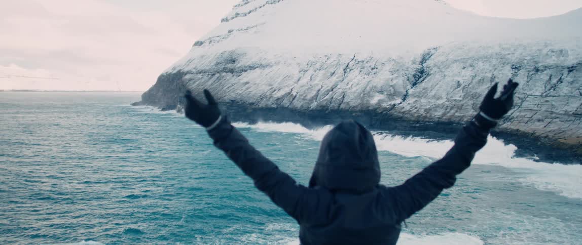 A person cheers by the shore